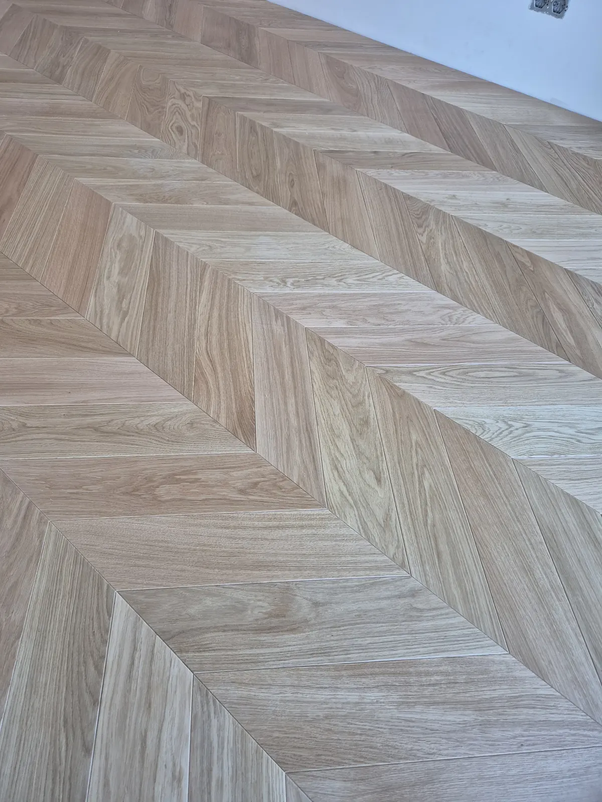 Zbliżenie łączeń jodełki francuskiej z naturalnego dębu – realizacja Deska Design