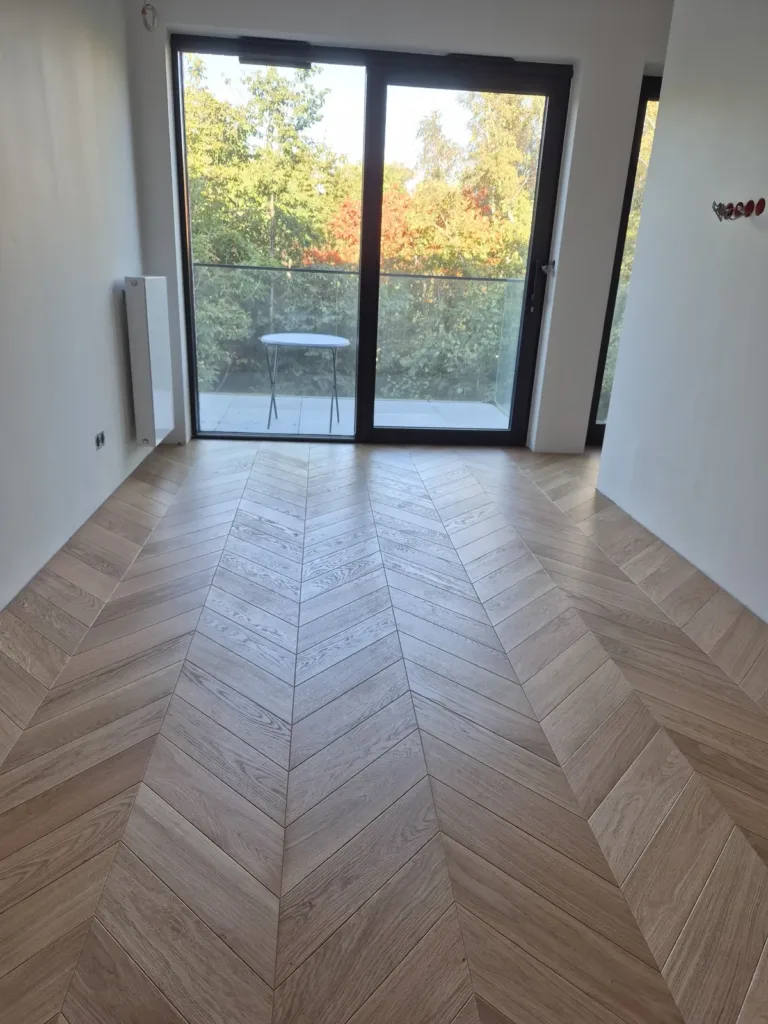 Jodełka francuska z jasnego dębu – pokój z balkonem Jodełka francuska z jasnego dębu w pokoju z wyjściem na balkon – realizacja Deska Design