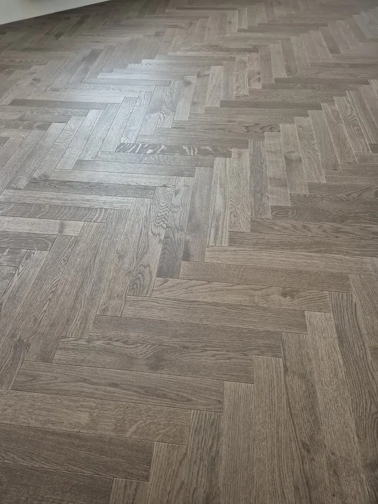 Zbliżenie klasycznej jodełki z ciemnego dębu – realizacja Deska Design w Sopocie