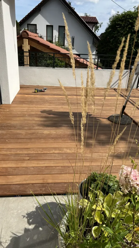 Taras z desek drewnianych Taras z desek drewnianych z trawami ozdobnymi przy domu – realizacja Deska Design